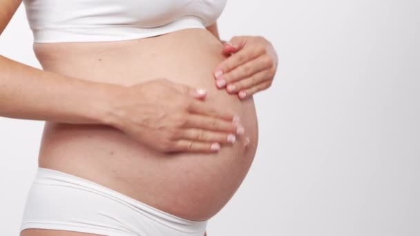 Giovane, felice e sana donna incinta su sfondo bianco. Video dello studio. Aspettativa del bambino, gravidanza e concetto di maternità. — Video Stock