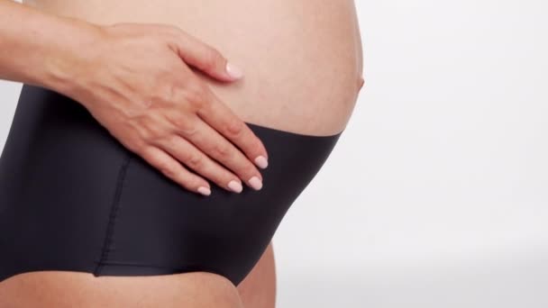 Νέα, ευτυχισμένη και υγιής έγκυος γυναίκα σε λευκό φόντο. Βίντεο στούντιο. Μωρό προσδοκία, την εγκυμοσύνη και την έννοια της μητρότητας. — Αρχείο Βίντεο