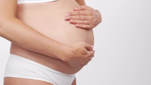 Fiatal, boldog és egészséges terhes nő fehér háttérrel. Stúdió videó. Baba elvárás, terhesség és anyaság koncepció. — Stock videók