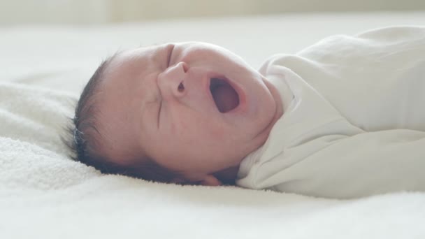 Gros plan d'un jeune bébé qui vient de naître. Un nouveau-né à la maison. Fenêtre lumineuse. — Video