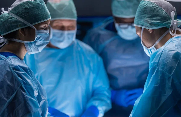 El equipo multirracial de cirujanos médicos profesionales realiza la operación quirúrgica en un hospital moderno. Los médicos están trabajando para salvar al paciente. Medicina, salud, cardiología y trasplante. —  Fotos de Stock