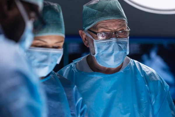 Une équipe multiraciale de chirurgiens médicaux professionnels effectue l'opération chirurgicale dans un hôpital moderne. Les médecins travaillent pour sauver le patient. Médecine, santé, cardiologie et transplantation. — Photo