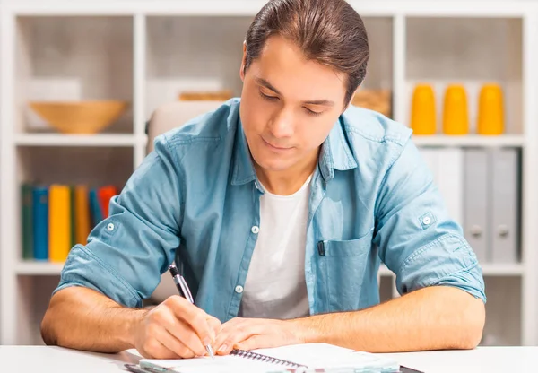 El joven trabaja en casa. Freelancer, trabajador remoto o lugar de trabajo estudiantil. Concepto de trabajo distante. —  Fotos de Stock