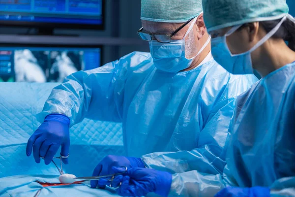 Une équipe multiraciale de chirurgiens médicaux professionnels effectue l'opération chirurgicale dans un hôpital moderne. Les médecins travaillent pour sauver le patient. Médecine, santé, cardiologie et transplantation. — Photo