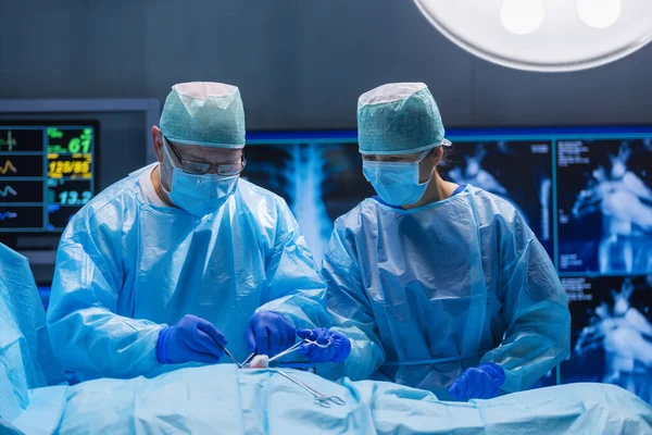 Equipe multirracial de cirurgiões médicos profissionais realiza a operação cirúrgica em um hospital moderno. Os médicos estão a trabalhar para salvar o paciente. Medicina, saúde, cardiologia e transplante. — Fotografia de Stock