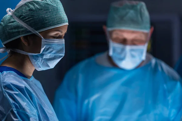 Wielorasowy zespół profesjonalnych lekarzy wykonuje operację chirurgiczną w nowoczesnym szpitalu. Lekarze pracują nad ratowaniem pacjenta. Medycyna, zdrowie, kardiologia i transplantacja. — Zdjęcie stockowe