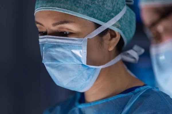 Wielorasowy zespół profesjonalnych lekarzy wykonuje operację chirurgiczną w nowoczesnym szpitalu. Lekarze pracują nad ratowaniem pacjenta. Medycyna, zdrowie, kardiologia i transplantacja. — Zdjęcie stockowe