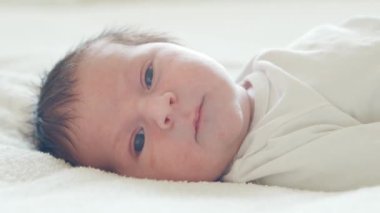 Yakın zamanda doğan bir bebeğin yakın plan portresi. Yeni doğmuş erkek bebek evde. Pencere ışığı.