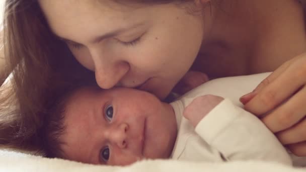 Az újszülött kisfiú és az anyja otthon vannak. Közelkép a csecsemőről, aki nemrég született. Ablakvilágítás. — Stock videók