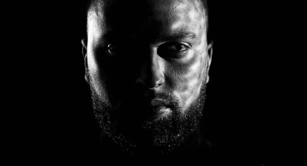 Close-up black and white portrait of brutal and handsome man over dark background. — Stock Photo, Image