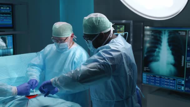 Team of professional medical surgeons performs the surgical operation in a modern hospital. Doctors are working to save the patient. Medicine, health, cardiology and transplantation concept. — 图库视频影像