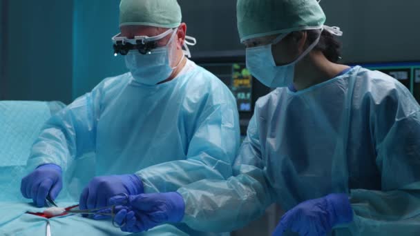 Team of professional medical surgeons performs the surgical operation in a modern hospital. Doctors are working to save the patient. Medicine, health, cardiology and transplantation concept. — Stock Video
