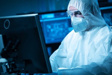 Bilim adamı mikro elektronik ve işlemcilerin araştırılması ve geliştirilmesi için modern bir bilim laboratuvarında çalışıyor. Mikroişlemci imalat işçisi bilgisayar teknolojisi ve ekipmanı kullanıyor.