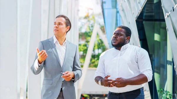 Concepto financiero, empresarial y de cooperación. Dos empresarios exitosos están hablando en la calle. Los trabajadores de oficina están discutiendo temas de negocios al aire libre. — Foto de Stock