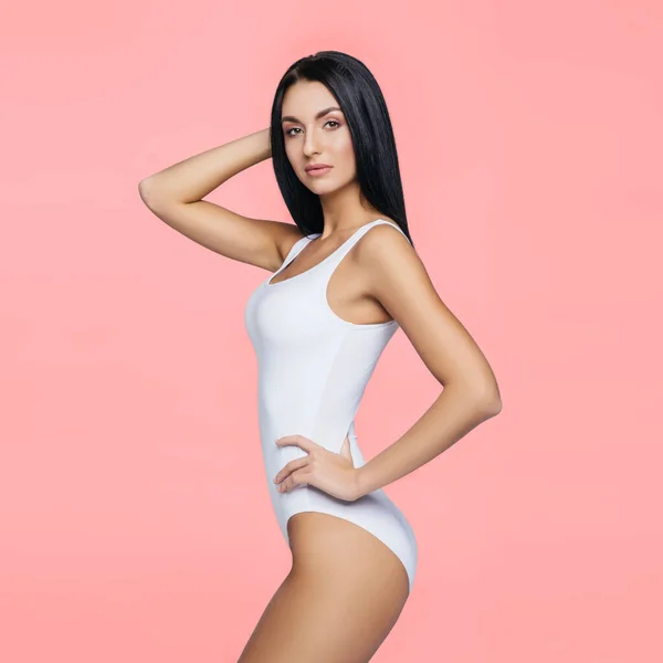 Chica morena atractiva y delgada en ropa interior blanca posando en el estudio. Vida sana, deporte y concepto de cuidado corporal. — Foto de Stock