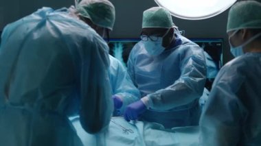 Profesyonel tıp cerrahlarından oluşan bir ekip modern bir hastanede cerrahi operasyon gerçekleştiriyor. Doktorlar hastayı kurtarmaya çalışıyor. Tıp, sağlık, kardiyoloji ve organ nakli kavramı.