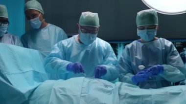 Profesyonel tıp cerrahlarından oluşan bir ekip modern bir hastanede cerrahi operasyon gerçekleştiriyor. Doktorlar hastayı kurtarmaya çalışıyor. Tıp, sağlık, kardiyoloji ve organ nakli kavramı.