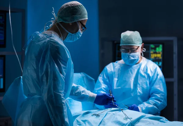 Equipe multirracial de cirurgiões médicos profissionais realiza a operação cirúrgica em um hospital moderno. Os médicos estão a trabalhar para salvar o paciente. Medicina, saúde, cardiologia e transplante. Fotos De Bancos De Imagens Sem Royalties