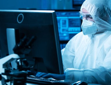 Bilim adamı mikro elektronik ve işlemcilerin araştırılması ve geliştirilmesi için modern bir bilim laboratuvarında çalışıyor. Mikroişlemci imalat işçisi bilgisayar teknolojisi ve ekipmanı kullanıyor.