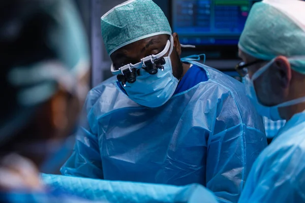 Multiraciale team van professionele chirurgen voert de chirurgische ingreep in een modern ziekenhuis. Artsen proberen de patiënt te redden. Geneeskunde, gezondheid en neurochirurgie. — Stockfoto