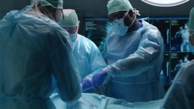 Profesyonel tıp cerrahlarından oluşan bir ekip modern bir hastanede cerrahi operasyon gerçekleştiriyor. Doktorlar hastayı kurtarmaya çalışıyor. Tıp, sağlık, kardiyoloji ve organ nakli kavramı.