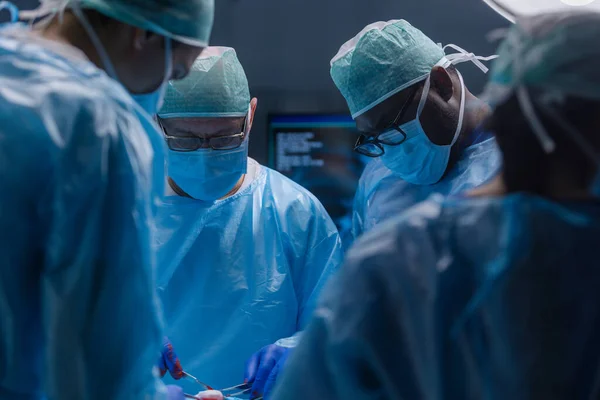 Multiraciale team van professionele chirurgen voert de chirurgische ingreep in een modern ziekenhuis. Artsen proberen de patiënt te redden. Geneeskunde, gezondheid, cardiologie en transplantatie. — Stockfoto