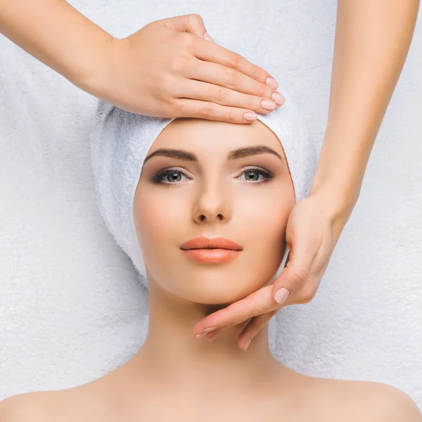 Mulher jovem e saudável recebe tratamentos de massagem para rosto, pele e pescoço no salão de spa. Conceito de saúde, bem-estar e rejuvenescimento. — Fotografia de Stock