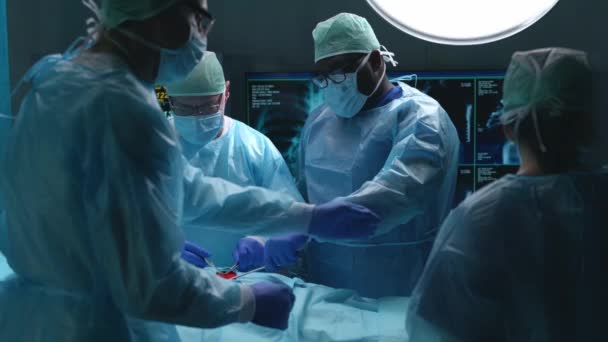Zespół profesjonalnych lekarzy wykonuje operację chirurgiczną w nowoczesnym szpitalu. Lekarze pracują nad ratowaniem pacjenta. Medycyna, zdrowie, kardiologia i koncepcja przeszczepu. — Wideo stockowe