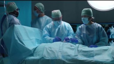 Profesyonel tıp cerrahlarından oluşan bir ekip modern bir hastanede cerrahi operasyon gerçekleştiriyor. Doktorlar hastayı kurtarmaya çalışıyor. Tıp, sağlık, kardiyoloji ve organ nakli kavramı.