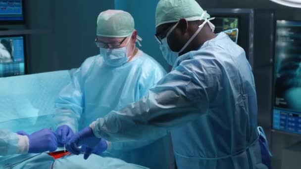 専門医のチームは、現代の病院で外科手術を行います。医者は患者を救うために働いている。医学、健康、心臓学、移植の概念. — ストック動画