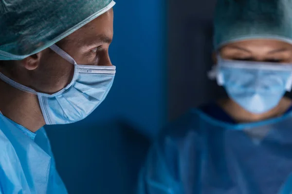 El equipo multirracial de cirujanos médicos profesionales realiza la operación quirúrgica en un hospital moderno. Los médicos están trabajando para salvar al paciente. Medicina, salud, cardiología y trasplante. —  Fotos de Stock