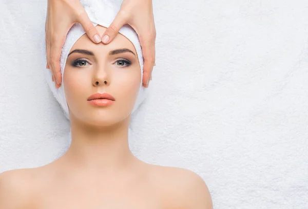 Jonge en gezonde vrouw krijgt massagebehandelingen voor gezicht, huid en nek in de spa salon. Gezondheid, welzijn en verjonging. — Stockfoto