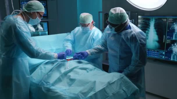 Team of professional medical surgeons performs the surgical operation in a modern hospital. Doctors are working to save the patient. Medicine, health, cardiology and transplantation concept. — 图库视频影像