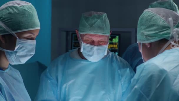 Ammattilaisten kirurgien tiimi suorittaa kirurgisen toimenpiteen nykyaikaisessa sairaalassa. Lääkärit yrittävät pelastaa potilaan. Lääkkeen, terveyden, kardiologian ja elinsiirtojen käsite. — kuvapankkivideo