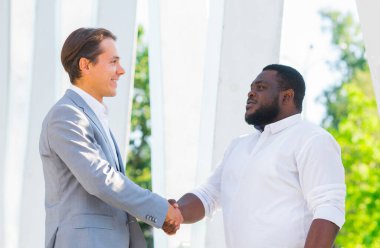 Finans, iş ve işbirliği konsepti. İki başarılı iş adamı sokakta konuşuyor. Ofis çalışanları iş meselelerini dışarıda tartışıyorlar..