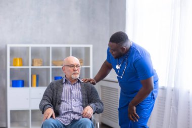 Bakıcı ve tekerlekli sandalyedeki yaşlı adam. Bakımevindeki profesyonel hemşire ve hasta. Yardım, rehabilitasyon ve sağlık hizmetleri.