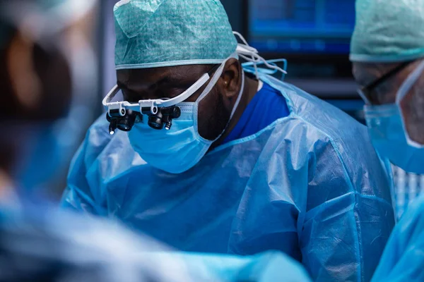 Multiraciale team van professionele chirurgen voert de chirurgische ingreep in een modern ziekenhuis. Artsen proberen de patiënt te redden. Geneeskunde, gezondheid en neurochirurgie. — Stockfoto