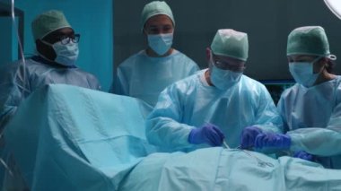 Profesyonel tıp cerrahlarından oluşan bir ekip modern bir hastanede cerrahi operasyon gerçekleştiriyor. Doktorlar hastayı kurtarmaya çalışıyor. Tıp, sağlık, kardiyoloji ve organ nakli kavramı.