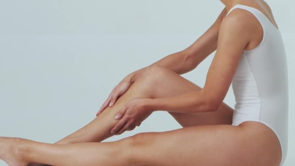 Chica joven, hermosa y deportiva en ropa interior adelgazante. Mujer en traje de baño blanco sobre gris. Cuidado de la piel y concepto de salud. — Vídeos de Stock