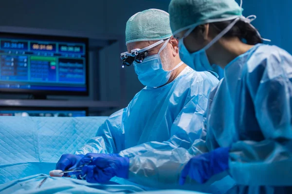 El equipo multirracial de cirujanos médicos profesionales realiza la operación quirúrgica en un hospital moderno. Los médicos están trabajando para salvar al paciente. Medicina, salud, cardiología y trasplante. —  Fotos de Stock