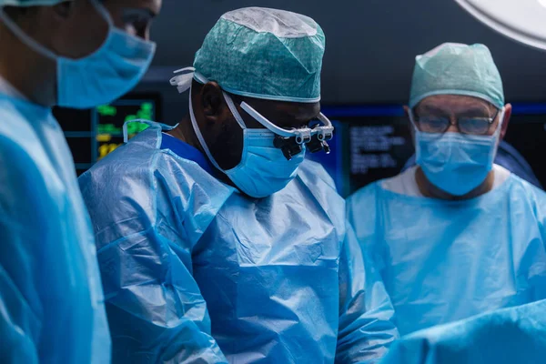El equipo multirracial de cirujanos médicos profesionales realiza la operación quirúrgica en un hospital moderno. Los médicos están trabajando para salvar al paciente. Medicina, salud y neurocirugía. — Foto de Stock