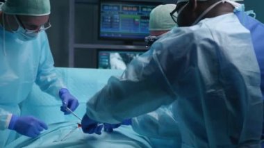 Profesyonel tıp cerrahlarından oluşan bir ekip modern bir hastanede cerrahi operasyon gerçekleştiriyor. Doktorlar hastayı kurtarmaya çalışıyor. Tıp, sağlık, kardiyoloji ve organ nakli kavramı.