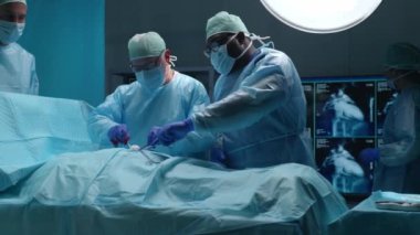 Profesyonel tıp cerrahlarından oluşan bir ekip modern bir hastanede cerrahi operasyon gerçekleştiriyor. Doktorlar hastayı kurtarmaya çalışıyor. Tıp, sağlık, kardiyoloji ve organ nakli kavramı.