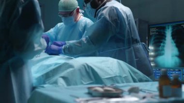 Profesyonel tıp cerrahlarından oluşan bir ekip modern bir hastanede cerrahi operasyon gerçekleştiriyor. Doktorlar hastayı kurtarmaya çalışıyor. Tıp, sağlık, kardiyoloji ve organ nakli kavramı.