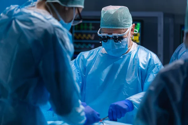 El equipo multirracial de cirujanos médicos profesionales realiza la operación quirúrgica en un hospital moderno. Los médicos están trabajando para salvar al paciente. Medicina, salud, cardiología y trasplante. —  Fotos de Stock