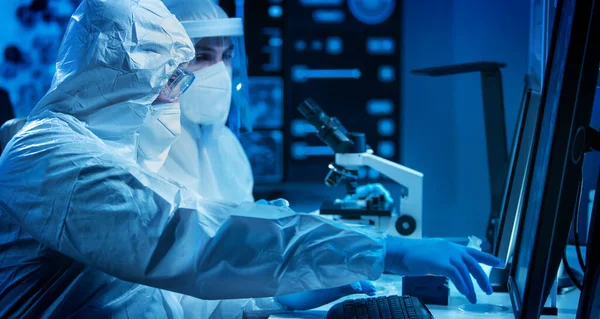 Los científicos trabajan en un laboratorio científico moderno utilizando equipos de laboratorio, microscopio y tecnología informática. Invención de nuevas vacunas. Concepto de Ciencia y Salud. — Foto de Stock