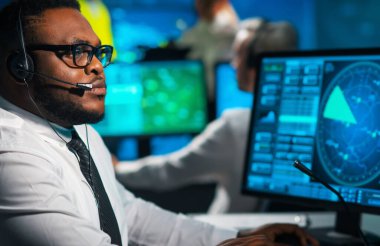 Uçak kontrol subayı kontrol kulesinden gelen uçakları izliyor. Hava hizmetleri ofisi navigasyon sistemleri, radarlar ve bilgisayar istasyonlarıyla donatılmıştır. Havacılık kavramı.