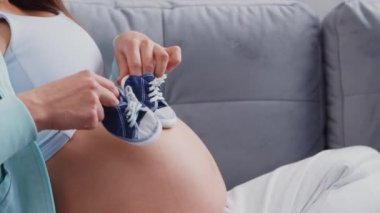 Genç hamile kadın evde dinleniyor ve bebek bekliyor. Hamilelik, annelik, sağlık ve yaşam tarzı kavramı.