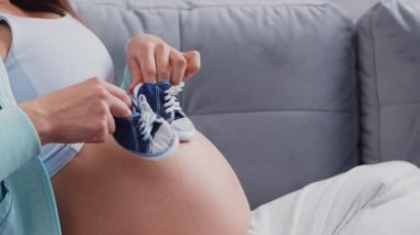 Genç hamile kadın evde dinleniyor ve bebek bekliyor. Hamilelik, annelik, sağlık ve yaşam tarzı kavramı.