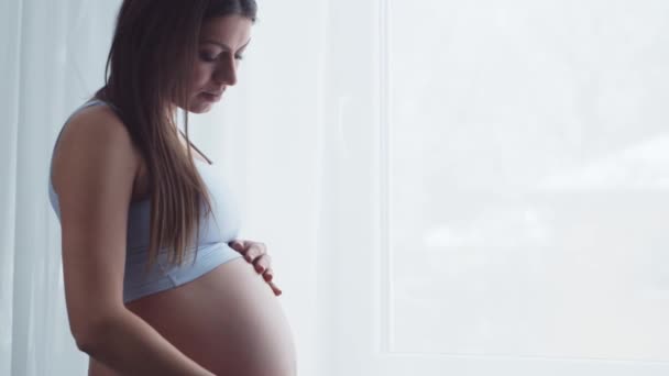 Jonge zwangere vrouw rust thuis en verwacht een baby. Het concept zwangerschap, moederschap, gezondheid en levensstijl. — Stockvideo